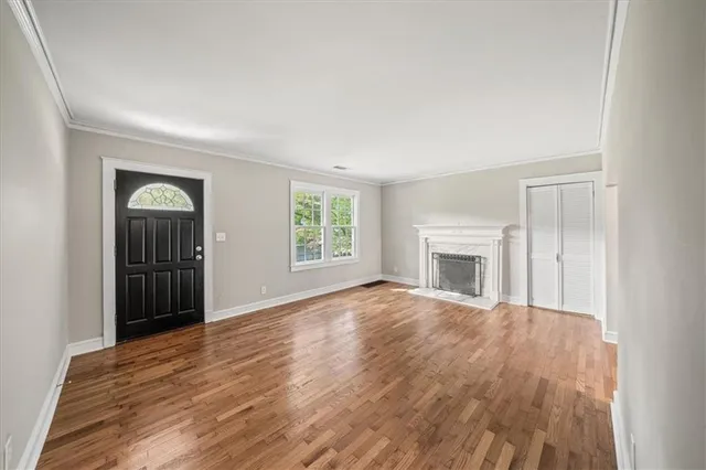 an empty room with windows and fireplace