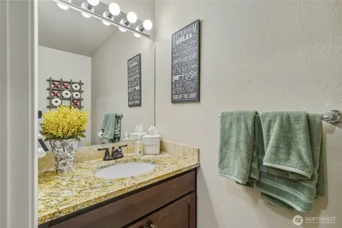 a bathroom with a granite countertop sink and a mirror