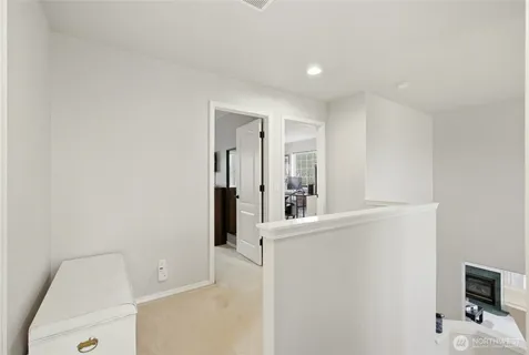 a view of a livingroom with wooden floor and a bathroom