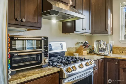 a kitchen with granite countertop a stove and a microwave