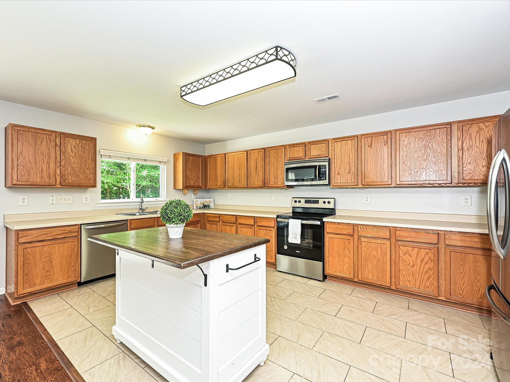 796 Ivy Trail Way Fort Mill, SC 29715 - Photo 11 of 39 a kitchen with stainless steel appliances granite countertop a stove top oven a sink dishwasher a dining table and chairs with wooden floor