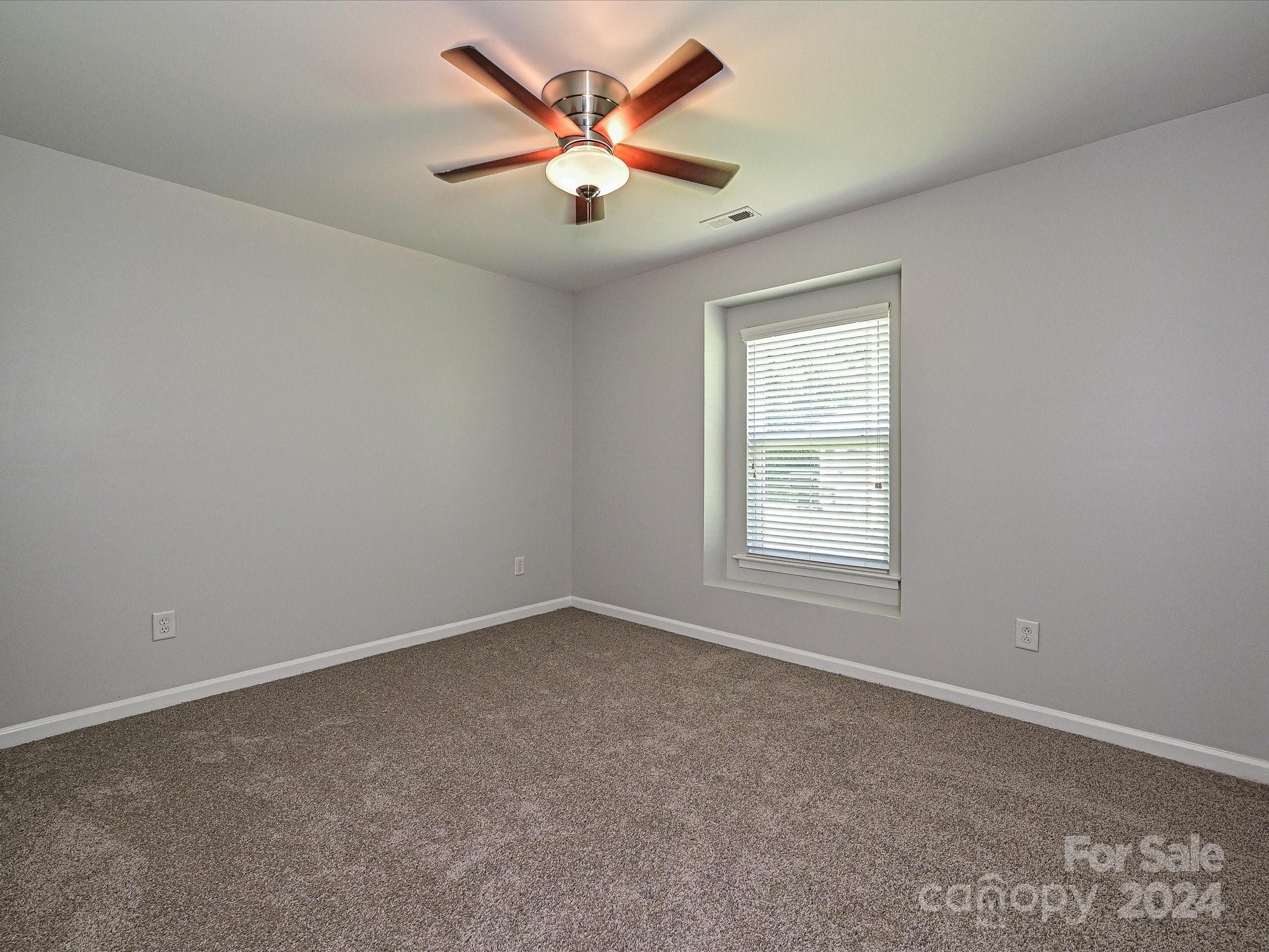 796 Ivy Trail Way Fort Mill, SC 29715 - Photo 29 of 39 an empty room with a window and a ceiling fan