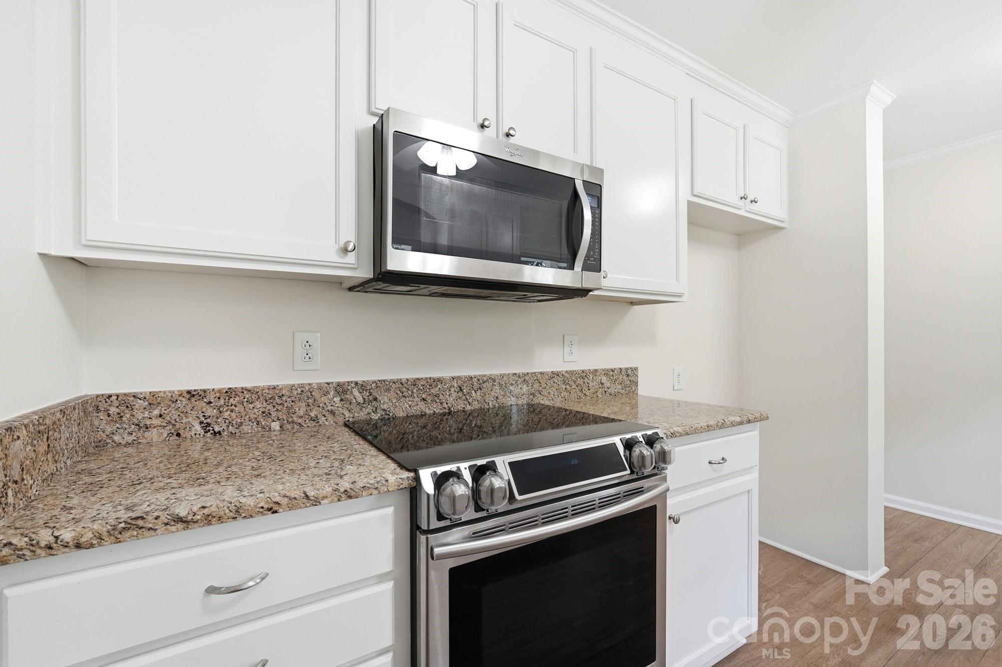 1235 Winecoff School Road Concord, NC 28027 - Photo 8 of 27 a kitchen with stainless steel appliances granite countertop white cabinets and a stove