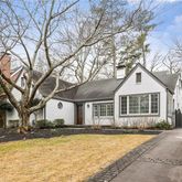 a front view of a house with a yard covered with snow