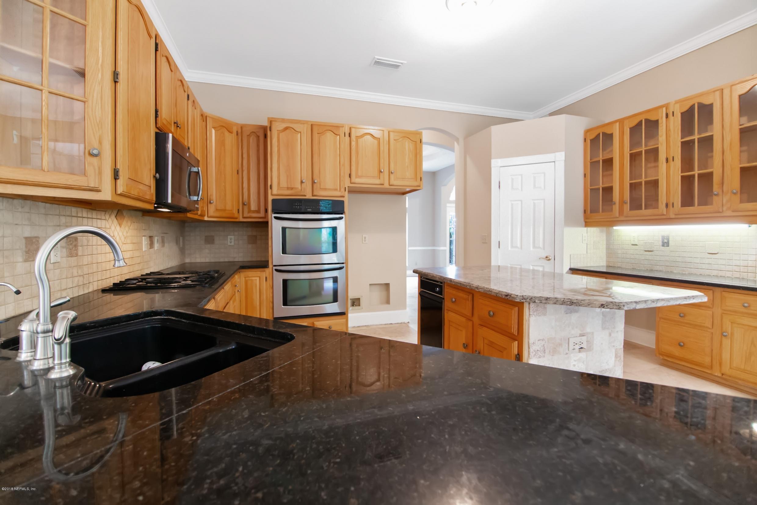 1899 Commodore Point Drive Orange Park, FL 32003 - Photo 2 of 52 a kitchen with granite countertop a stove a sink and a microwave