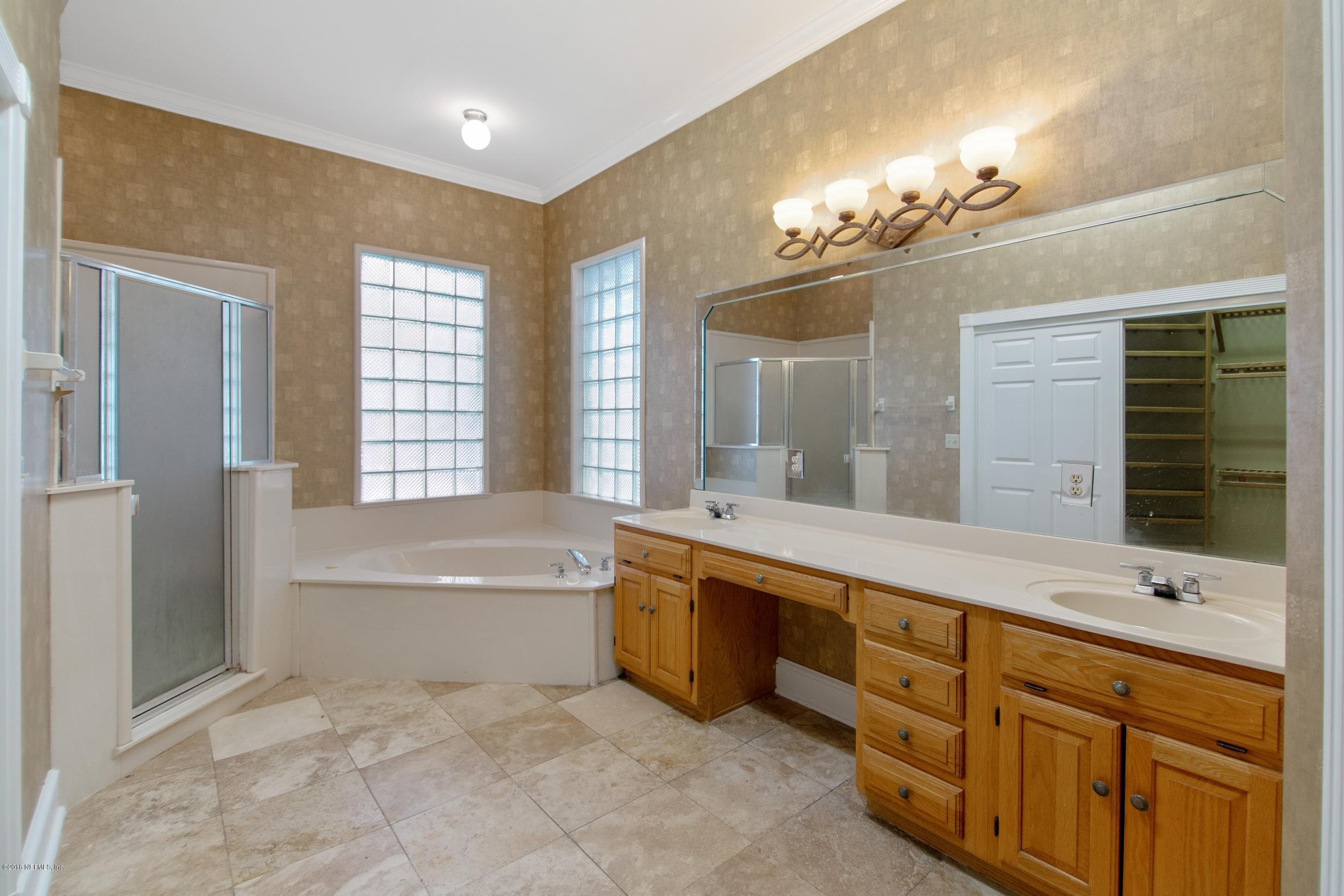 1899 Commodore Point Drive Orange Park, FL 32003 - Photo 36 of 52 a spacious bathroom with a double vanity sink a large mirror and a bathtub