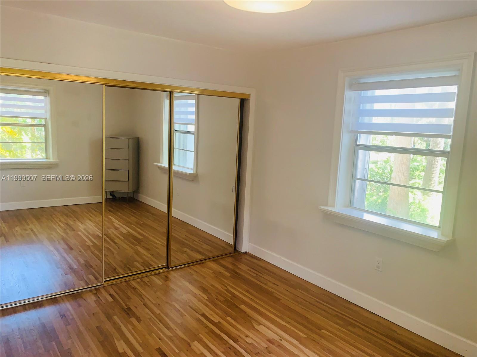 5605 Southwest 80th Street, Unit 97A Miami, FL 33143 - Photo 13 of 25 a view of empty room with wooden floor and fan