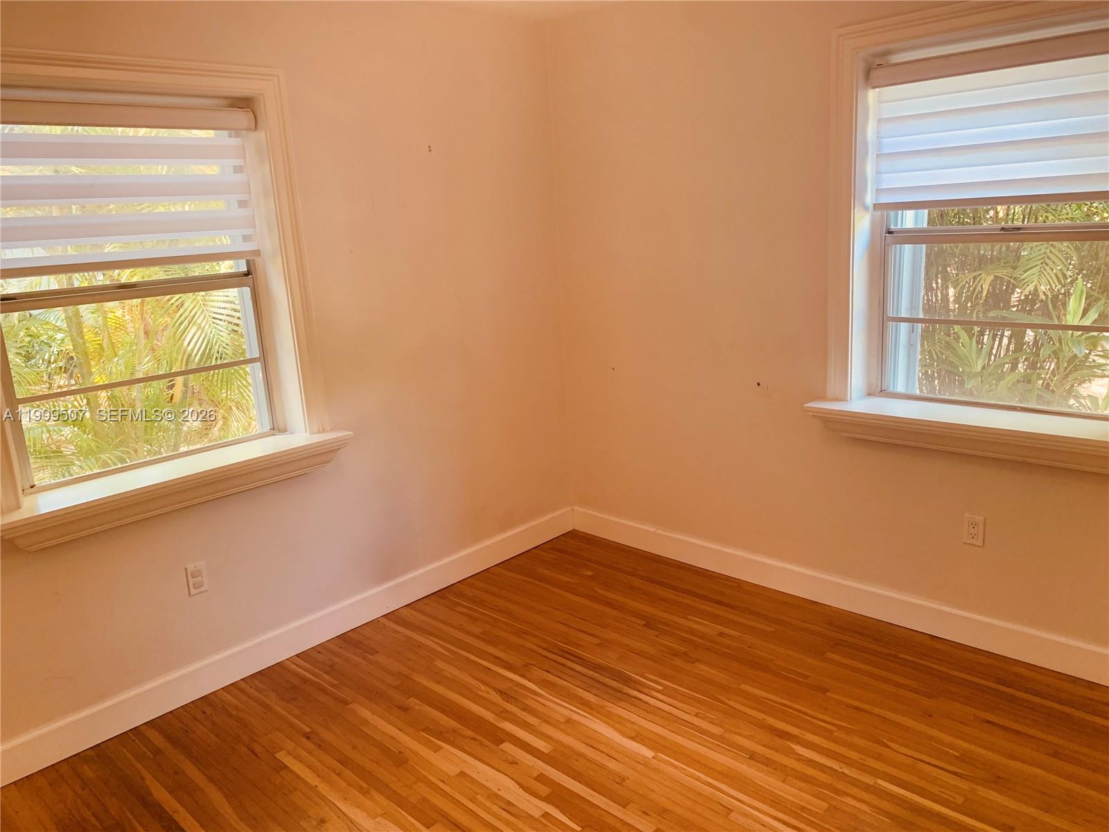 5605 Southwest 80th Street, Unit 97A Miami, FL 33143 - Photo 15 of 25 a view of an empty room with wooden floor and a window