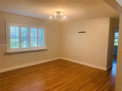 a view of a room with wooden floor and windows