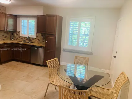 a kitchen with stainless steel appliances granite countertop a refrigerator a stove a sink dishwasher with a dining table and chair