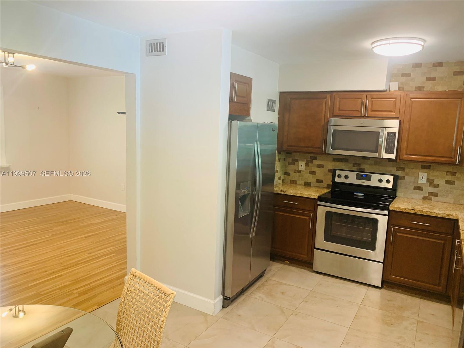 5605 Southwest 80th Street, Unit 97A Miami, FL 33143 - Photo 8 of 25 a kitchen with a refrigerator stove and microwave