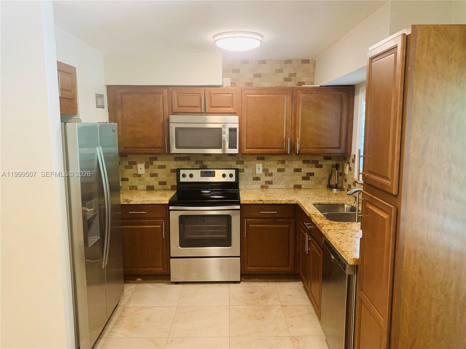 5605 Southwest 80th Street, Unit 97A Miami, FL 33143 - Photo 9 of 25 a kitchen with stainless steel appliances a refrigerator stove and sink