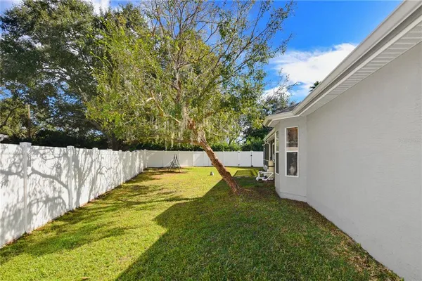 an aerial view of a house with a yard and wooden fence