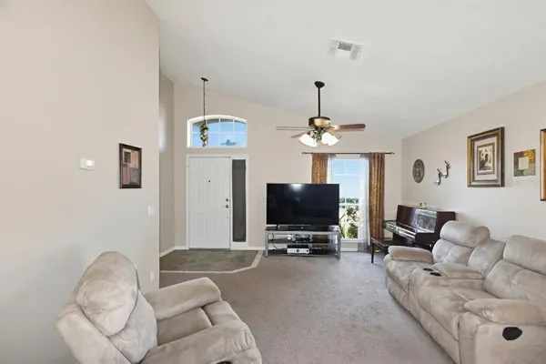 a living room with furniture a chandelier and a flat screen tv