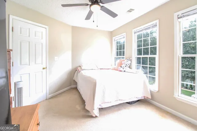 a spacious bedroom with a bed and a large window