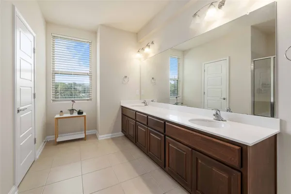 a spacious bathroom with a double vanity sink large mirror and a bathtub