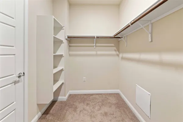 a view of walk in closet with empty racks