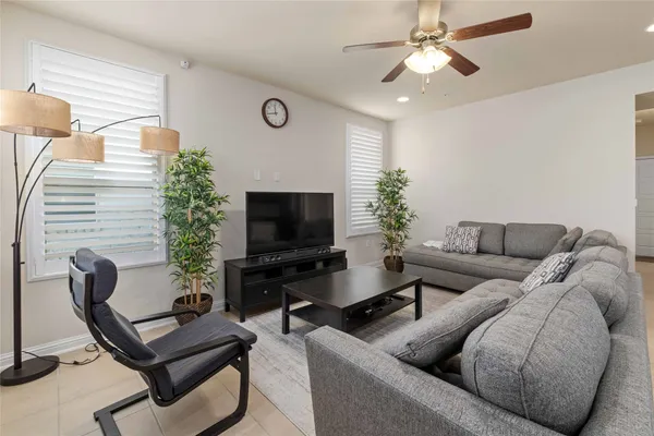 a living room with furniture a flat screen tv and a window