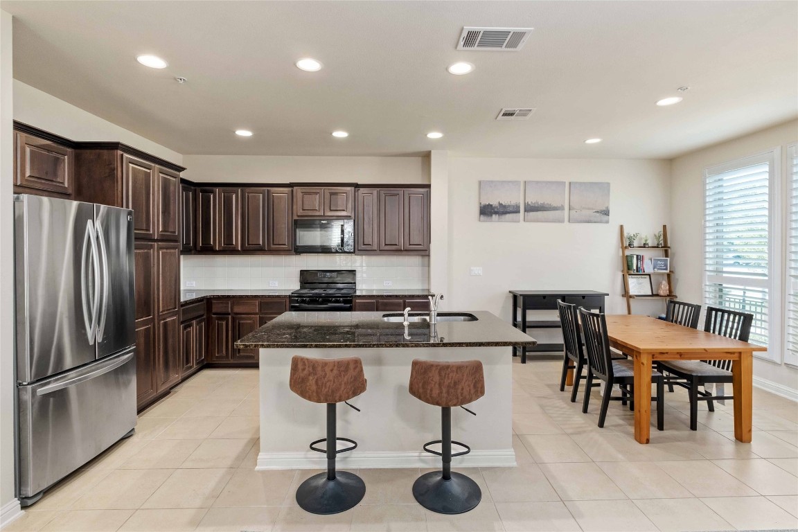 6814 East Riverside Drive, Unit 31 Austin, TX 78741 - Photo 8 of 25 a kitchen with stainless steel appliances granite countertop a stove a sink a refrigerator and chairs