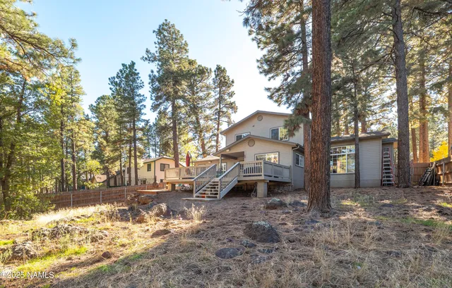 a backyard of a house with wooden fence and large trees