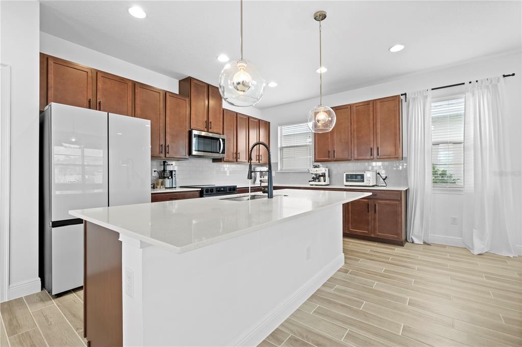 6699 Alder Road St. Cloud, FL 34773 - Photo 14 of 51 a kitchen with stainless steel appliances granite countertop a refrigerator a sink a stove and a oven