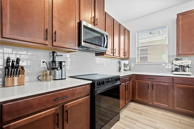 a kitchen with stainless steel appliances granite countertop a sink stove and microwave