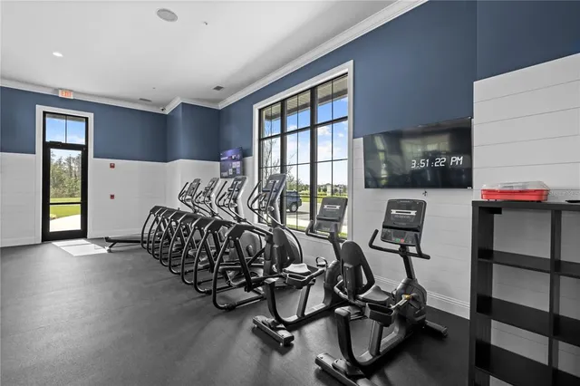 a room with gym equipment and large windows