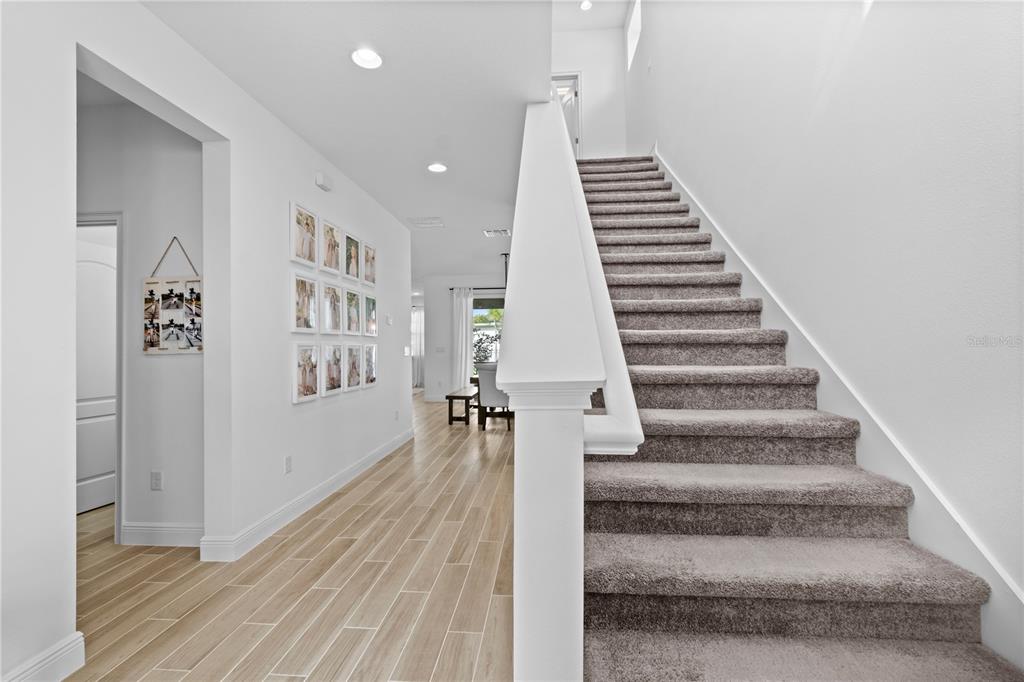 6699 Alder Road St. Cloud, FL 34773 - Photo 6 of 51 a view of staircase with wooden floor and white walls