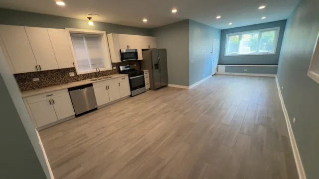 a kitchen with granite countertop a stove a sink and a refrigerator
