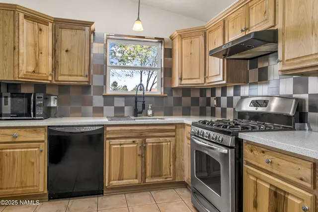 a kitchen with stainless steel appliances granite countertop a stove sink and cabinets