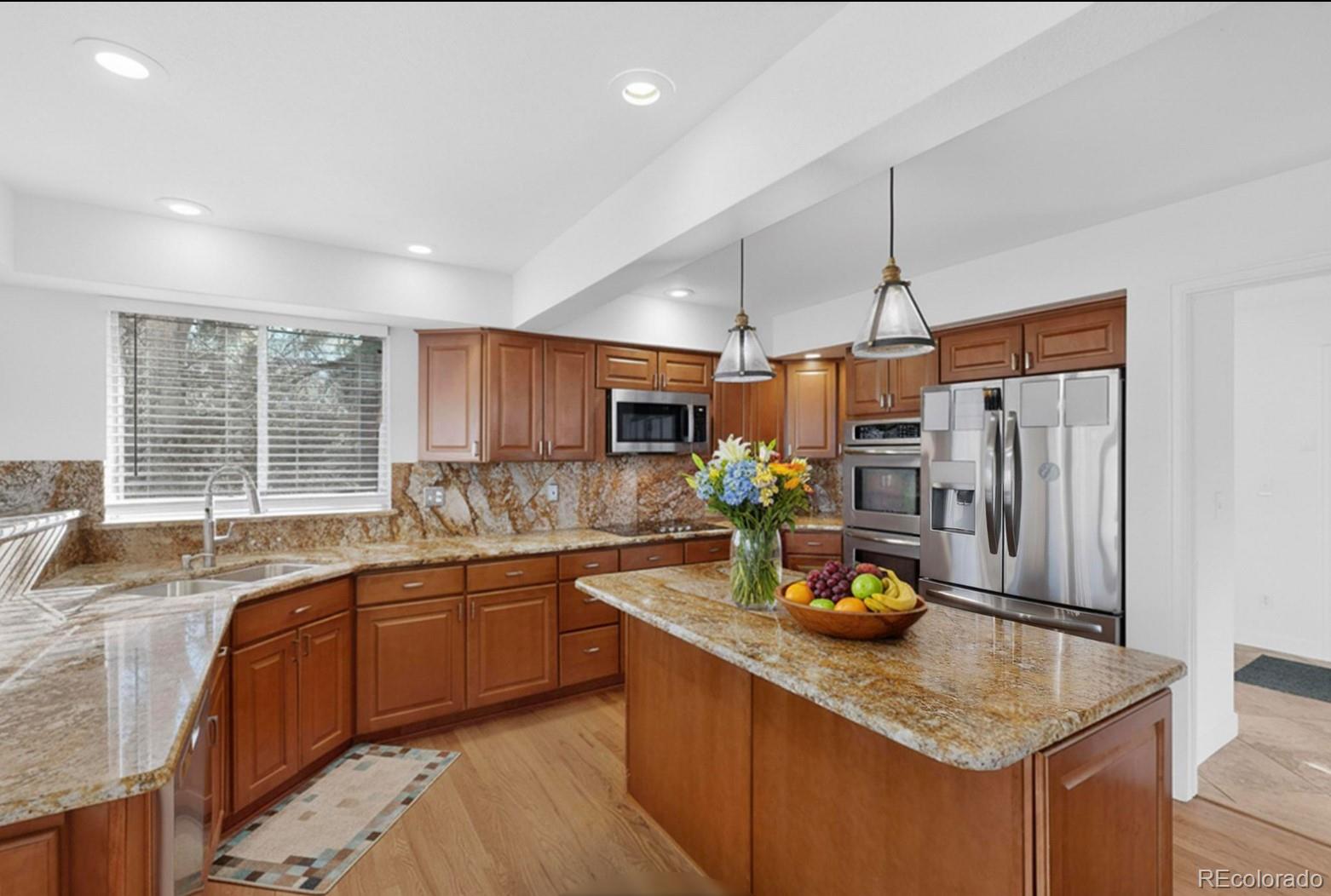 9195 Sugarstone Circle Highlands Ranch, CO 80130 - Photo 4 of 37 a kitchen with stainless steel appliances granite countertop a sink refrigerator and cabinets