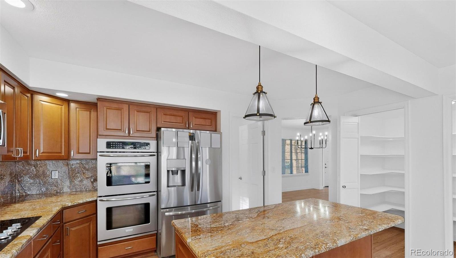 9195 Sugarstone Circle Highlands Ranch, CO 80130 - Photo 7 of 37 a kitchen with stainless steel appliances granite countertop a refrigerator a stove and a sink