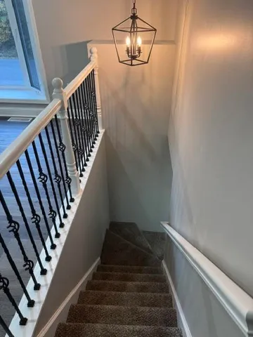 a view of staircase with railing and white walls