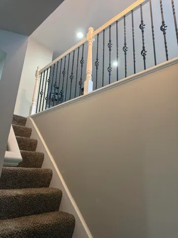 a view of staircase with lots of frames on wall