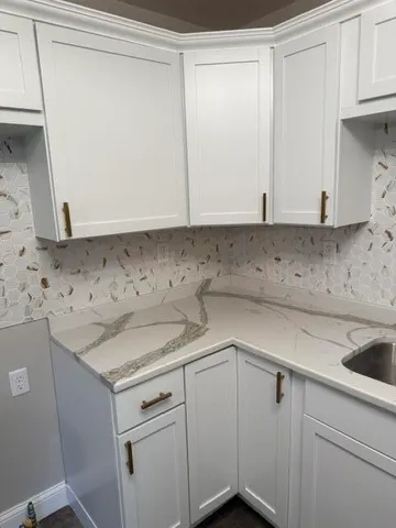 a view of cabinets a sink and dishwasher in a white cabinet