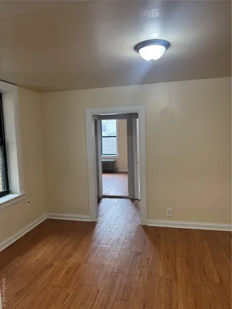 an empty room with wooden floor and closet