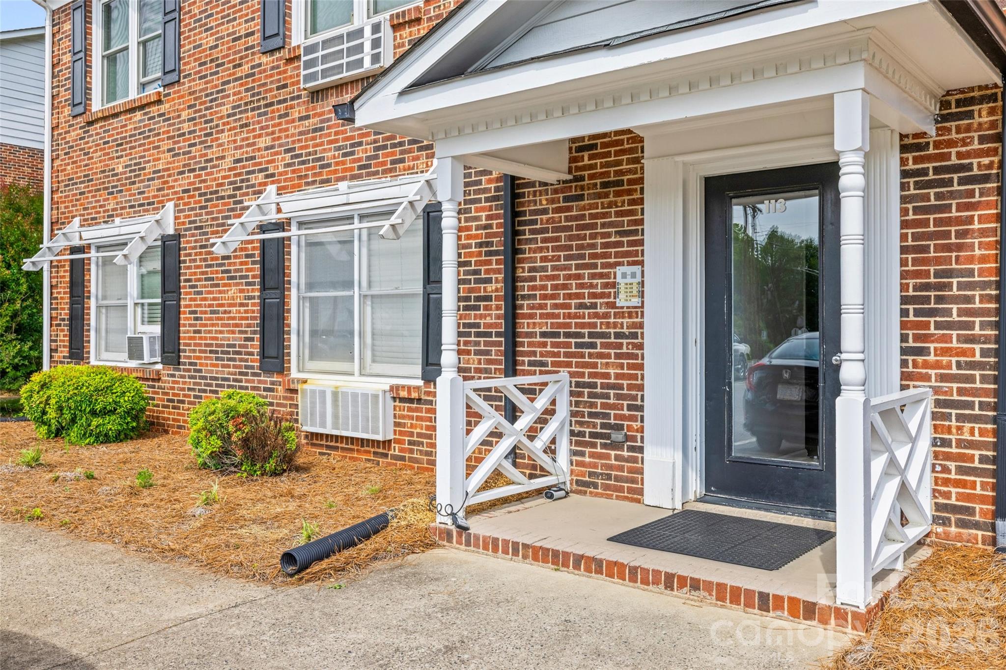 113 Stroupe Road, Unit E Gastonia, NC 28056 - Photo 2 of 33 a house with potted plants in front of door
