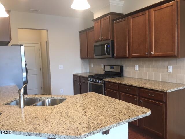 134 Zante Currant Road, Unit 134 Durham, NC 27703 - Photo 3 of 14 a kitchen with stainless steel appliances granite countertop a sink stove and refrigerator