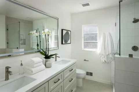 a bathroom with a double vanity sink mirror and toilet
