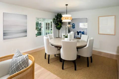 a dining room with furniture a window and wooden floor