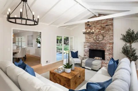 a living room with furniture a table and a chandelier
