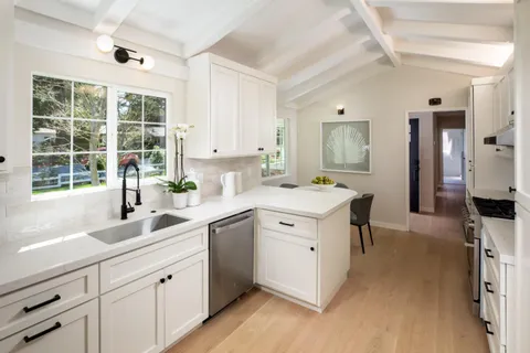 a kitchen that has a sink and a stove in it