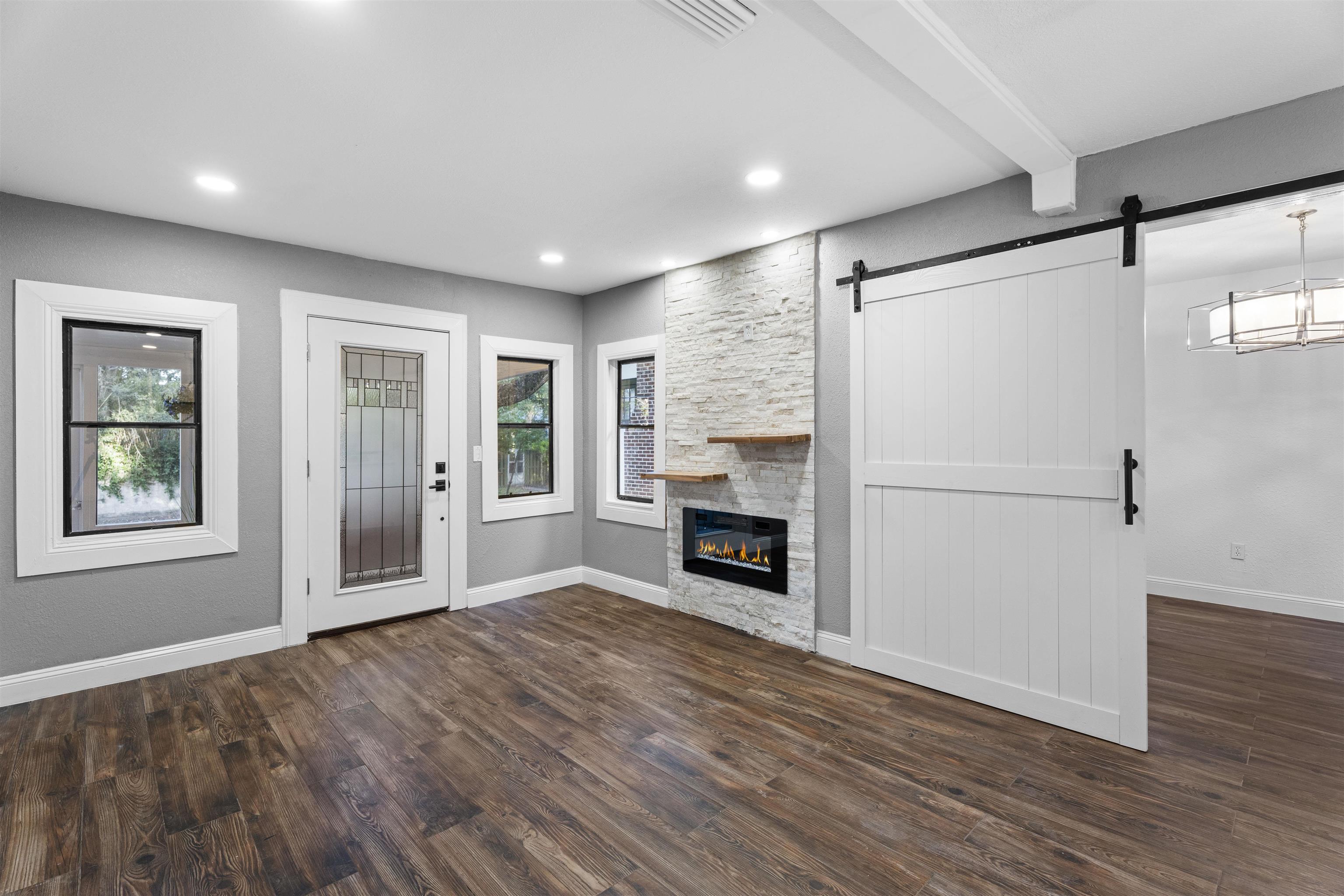 136 Washington Street St. Augustine, FL 32084 - Photo 11 of 50 an empty room with windows a fireplace and wooden floor