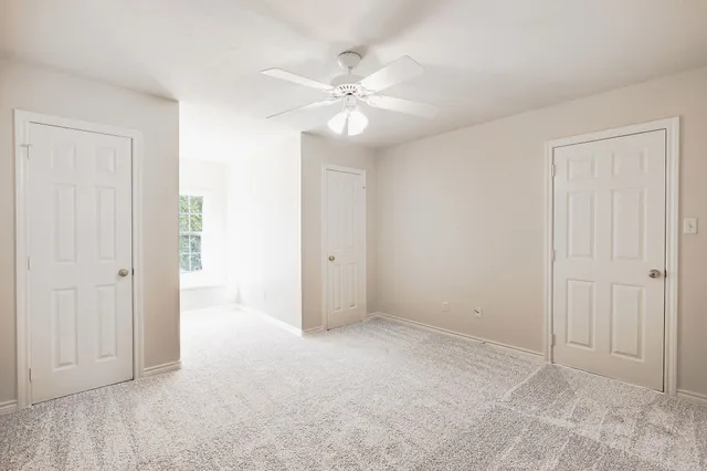 a view of an empty room with a ceiling fan