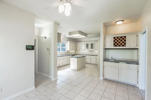 a kitchen with white cabinets and appliances