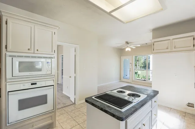 a kitchen with white cabinets and white appliances