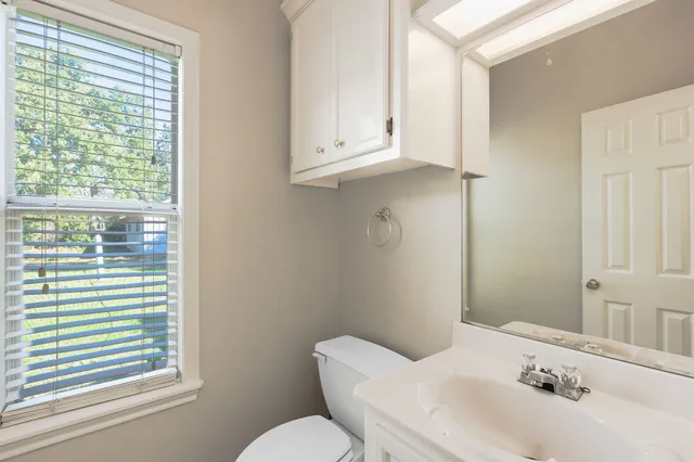 a bathroom with a sink mirror and toilet