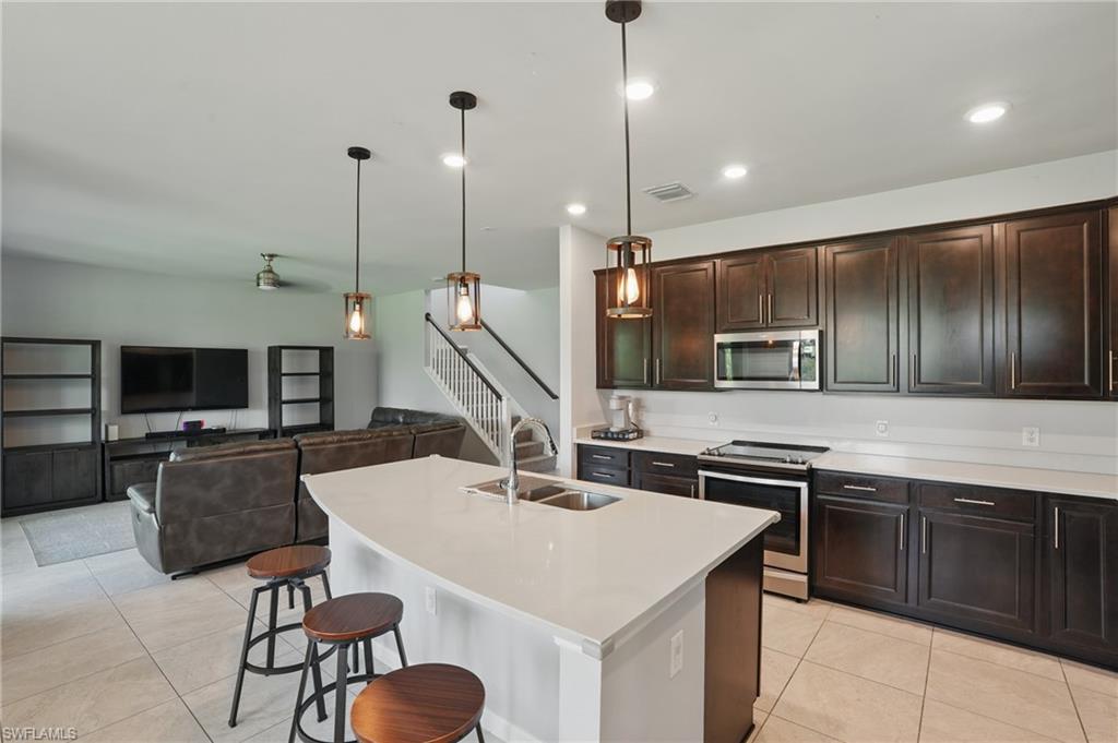 4934 Seton Way Ave Maria, FL 34142 - Photo 11 of 49 a kitchen with kitchen island granite countertop a sink a counter space appliances and cabinets