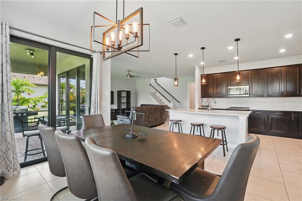 4934 Seton Way Ave Maria, FL 34142 - Photo 13 of 49 a view of a dining room with furniture a chandelier and wooden floor