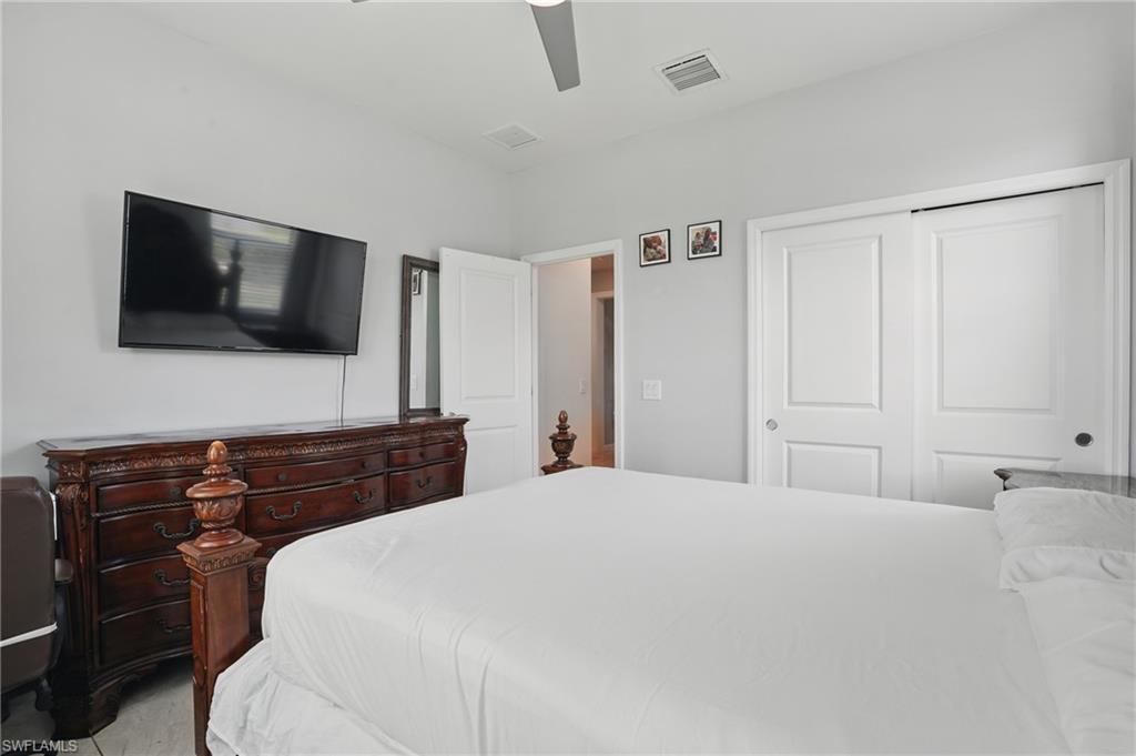 4934 Seton Way Ave Maria, FL 34142 - Photo 29 of 49 a bedroom with a large bed and a flat screen tv